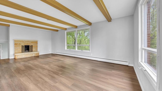 1007 Forest Hill Dr, Green Bay, WI 54311 - unfurnished living room with a baseboard heating unit, beamed ceiling, wood finished floors, a fireplace, and baseboards