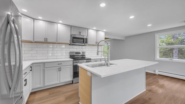 1007 Forest Hill Dr, Green Bay, WI 54311 - kitchen featuring stainless steel appliances, a sink, wood finished floors, decorative backsplash, and recessed lighting