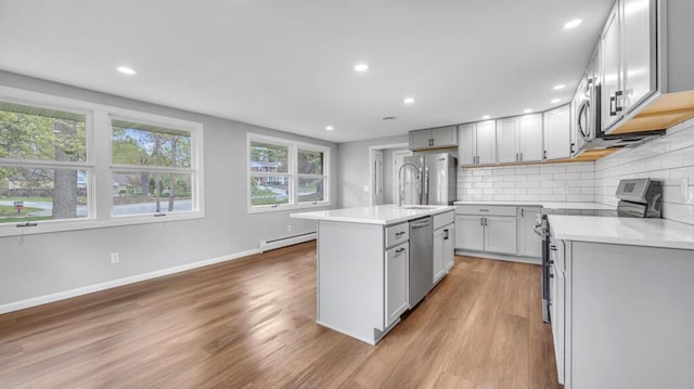 1007 Forest Hill Dr, Green Bay, WI 54311 - kitchen featuring baseboard heating, stainless steel appliances, light wood finished floors, baseboards, and recessed lighting