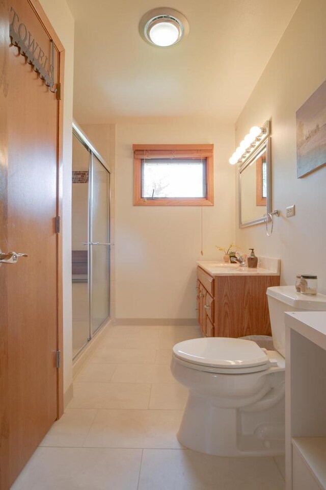 1349 93rd Ave, Kenosha, WI 53144 - full bathroom featuring vanity, toilet, a stall shower, and tile patterned flooring