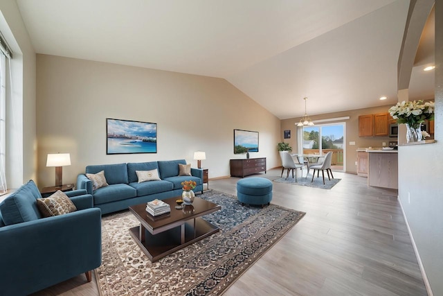 5406 Rock Rapids Dr, Weston, WI 54476 - living room featuring lofted ceiling, light wood-style floors, baseboards, and a chandelier
