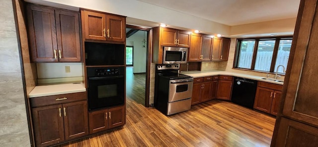 3315 N 12th St, Wausau, WI 54403 - kitchen featuring black appliances, a sink, wood finished floors, and light countertops