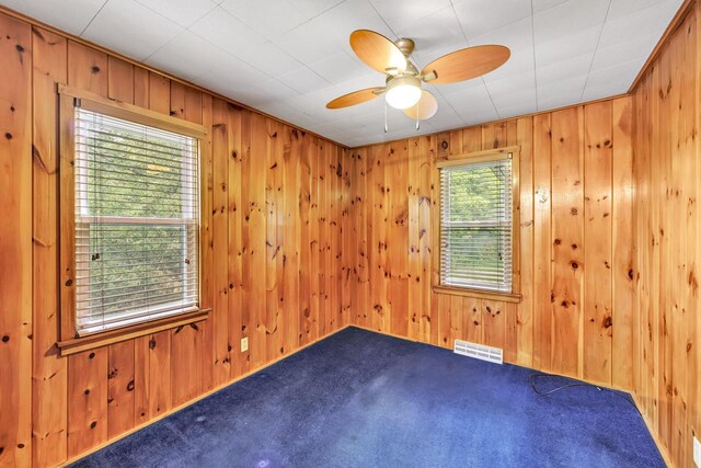 N7119 River Dr, Shawano, WI 54166 - empty room featuring carpet flooring, a ceiling fan, and wooden walls