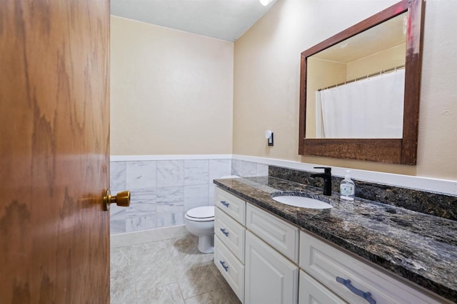 1416 21st Ave S, Wisconsin Rapids, WI 54495 - bathroom with toilet, vanity, wainscoting, and tile walls