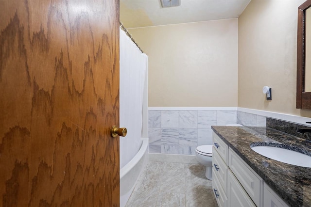 1416 21st Ave S, Wisconsin Rapids, WI 54495 - bathroom featuring toilet, vanity, a wainscoted wall, and shower / bath combo with shower curtain