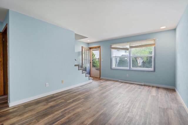 1416 21st Ave S, Wisconsin Rapids, WI 54495 - unfurnished room with wood finished floors, a baseboard heating unit, stairs, baseboards, and recessed lighting