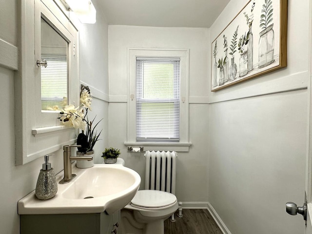 4416 75th St, Kenosha, WI 53142 - half bath featuring radiator, wood finished floors, toilet, baseboards, and vanity