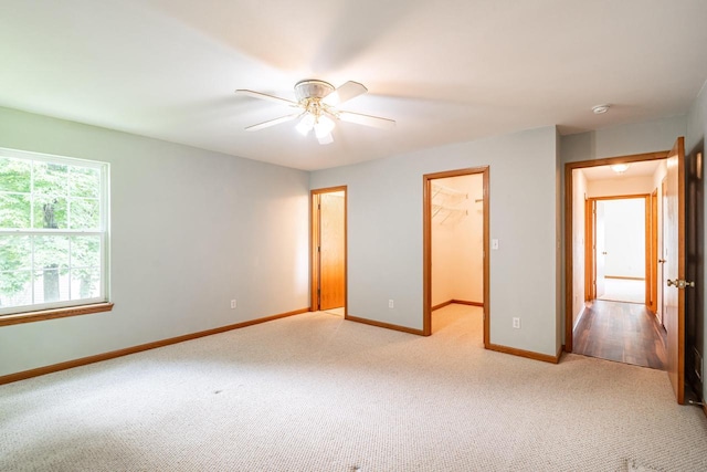 N100W14330 Sunburst Trl, Germantown, WI 53022 - unfurnished bedroom with light carpet, baseboards, a walk in closet, a closet, and ceiling fan