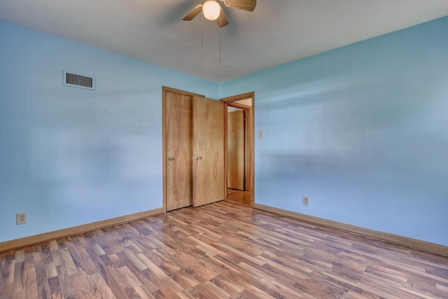 167 Po St, West Bend, WI 53090 - unfurnished bedroom featuring baseboards, wood finished floors, ceiling fan, and a closet