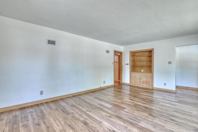 167 Po St, West Bend, WI 53090 - empty room with built in shelves, light wood-type flooring, and baseboards