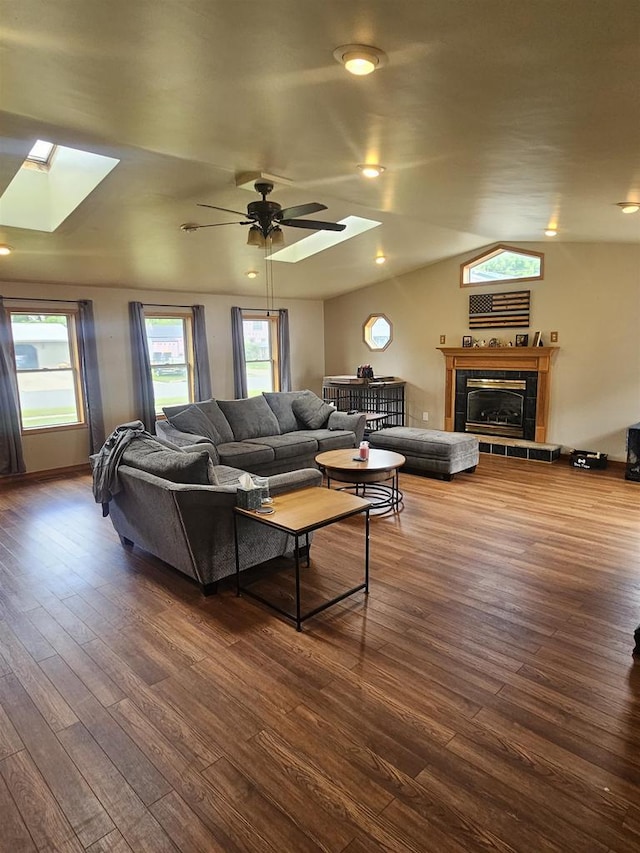 301 Superior St, Boscobel, WI 53805 - living room with a skylight, dark wood-style flooring, ceiling fan, vaulted ceiling, and a tiled fireplace