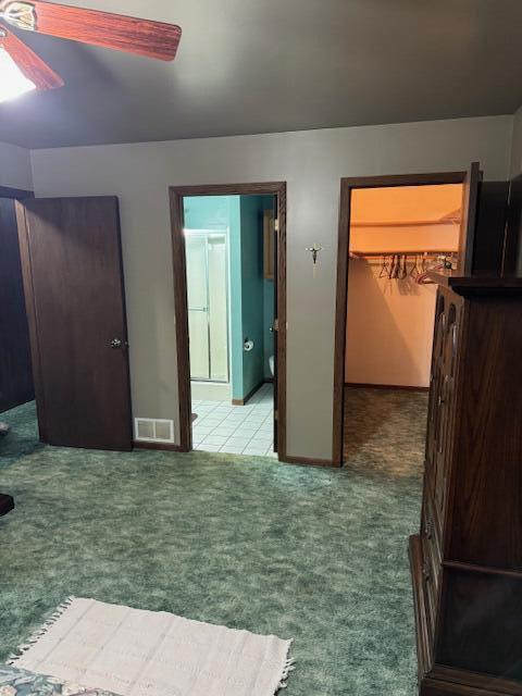 W6782 Marine Dr, Markesan, WI 53946 - bedroom with a walk in closet, light colored carpet, ceiling fan, and baseboards