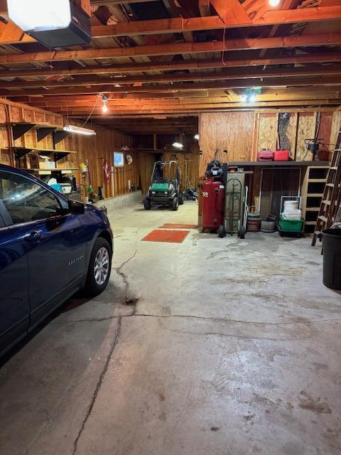 W6782 Marine Dr, Markesan, WI 53946 - garage featuring wood walls and a garage door opener