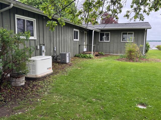 W6782 Marine Dr, Markesan, WI 53946 - back of house featuring board and batten siding and a yard