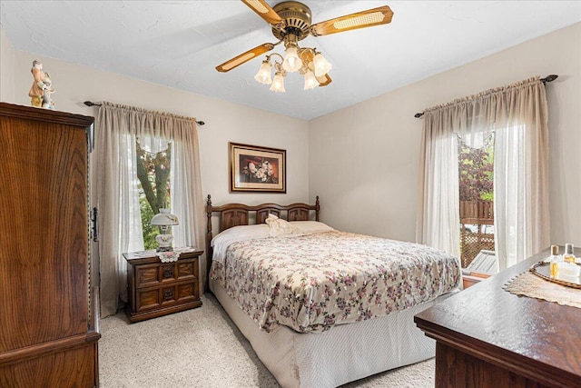611 Highland Ave, Kewaskum, WI 53040 - bedroom with multiple windows, access to exterior, light colored carpet, and a ceiling fan