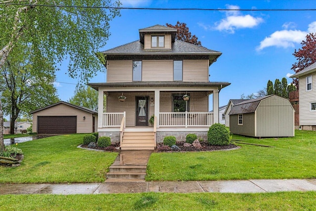 611 Highland Ave, Kewaskum, WI 53040 - traditional style home featuring a detached garage, a porch, a front lawn, and a shingled roof