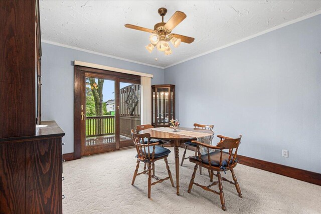 611 Highland Ave, Kewaskum, WI 53040 - dining space featuring light colored carpet, ceiling fan, baseboards, and crown molding