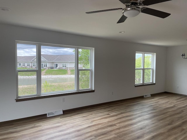 412 Emerald Ct, Kewaskum, WI 53040 - spare room featuring healthy amount of natural light, wood finished floors, and baseboards