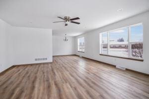 412 Emerald Ct, Kewaskum, WI 53040 - unfurnished living room with wood finished floors, a ceiling fan, and a chandelier