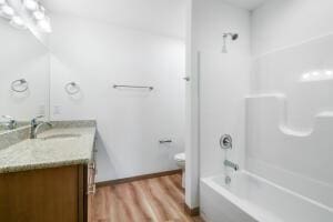 412 Emerald Ct, Kewaskum, WI 53040 - bathroom with vanity, wood finished floors, shower / bathtub combination, and toilet