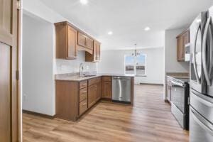 412 Emerald Ct, Kewaskum, WI 53040 - kitchen featuring appliances with stainless steel finishes, a sink, brown cabinetry, light wood-type flooring, and recessed lighting