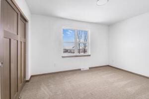 412 Emerald Ct, Kewaskum, WI 53040 - unfurnished bedroom with light carpet, baseboards, and a closet