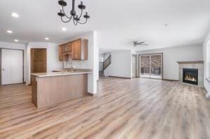 412 Emerald Ct, Kewaskum, WI 53040 - kitchen featuring open floor plan, recessed lighting, light countertops, a peninsula, and a lit fireplace