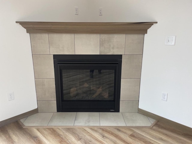 412 Emerald Ct, Kewaskum, WI 53040 - detailed view of a tiled fireplace, baseboards, and wood finished floors