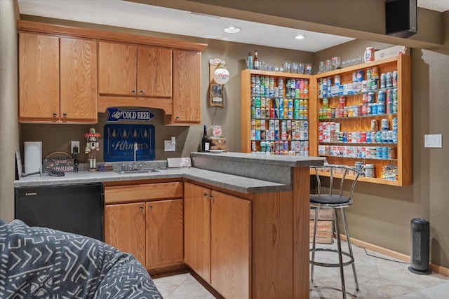 405 August Hills Dr, La Crescent, MN 55947 - kitchen featuring a sink, a peninsula, a breakfast bar, light tile patterned flooring, and baseboards