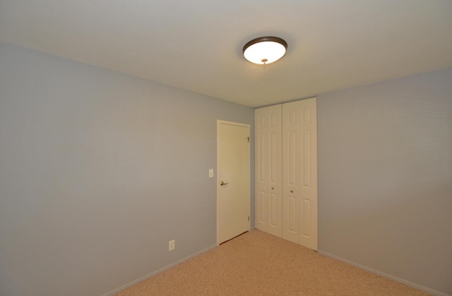 12100 44th Ave, Pleasant Prairie, WI 53158 - unfurnished bedroom featuring a closet, light colored carpet, and baseboards