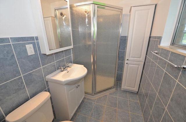12100 44th Ave, Pleasant Prairie, WI 53158 - bathroom with tile walls, vanity, tile patterned floors, a shower stall, and toilet