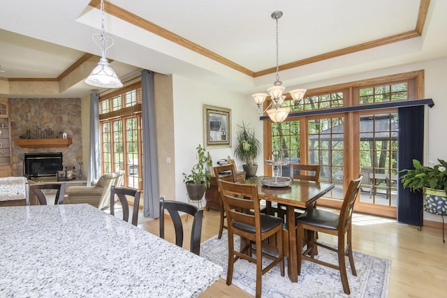 W360S9910 Markham Rd, Eagle, WI 53119 - dining space with a raised ceiling, crown molding, light wood finished floors, a stone fireplace, and a chandelier