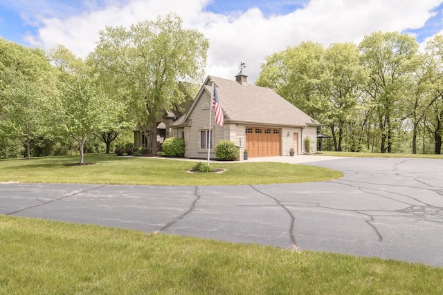 W360S9910 Markham Rd, Eagle, WI 53119 - view of side of home featuring a chimney, a lawn, driveway, and a garage