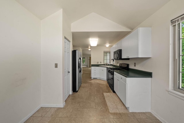 500 S Edwards Blvd Unit 1, Lake Geneva, WI 53147 - kitchen with black appliances, dark countertops, white cabinets, baseboards, and lofted ceiling