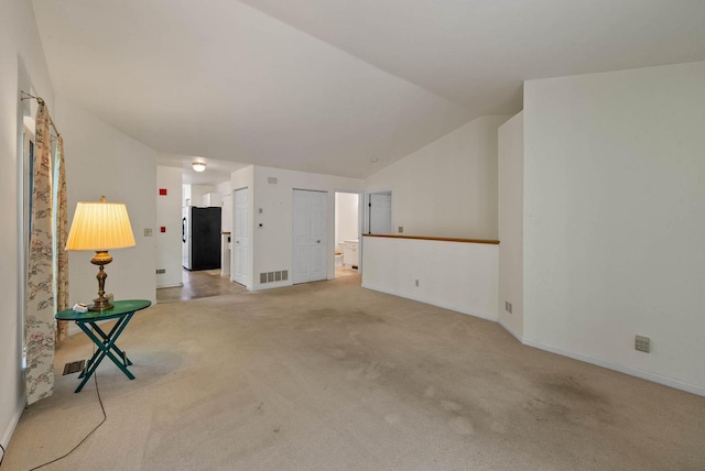500 S Edwards Blvd Unit 1, Lake Geneva, WI 53147 - spare room featuring light carpet, vaulted ceiling, and baseboards