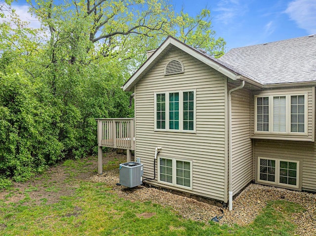 500 S Edwards Blvd Unit 1, Lake Geneva, WI 53147 - view of side of home featuring central AC unit, roof with shingles, a wooden deck, and a yard