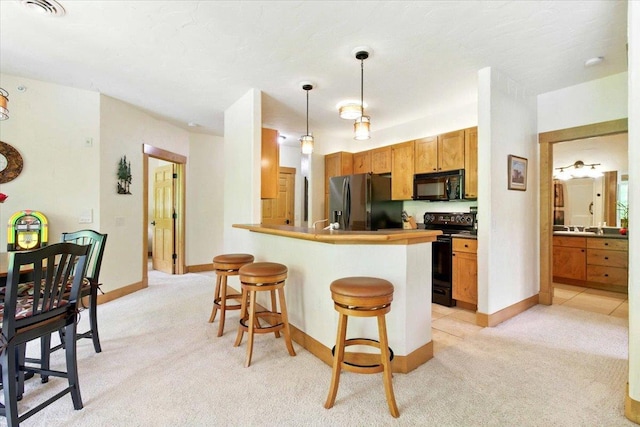 441 Clara Ave Unit 115, Wisconsin Dells, WI 53965 - kitchen with black appliances, light carpet, a breakfast bar, and a peninsula