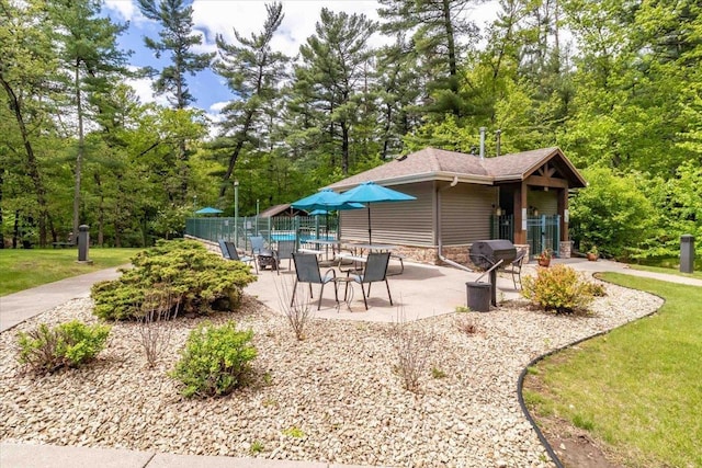 441 Clara Ave Unit 115, Wisconsin Dells, WI 53965 - rear view of house with a patio, view of scattered trees, and a shingled roof