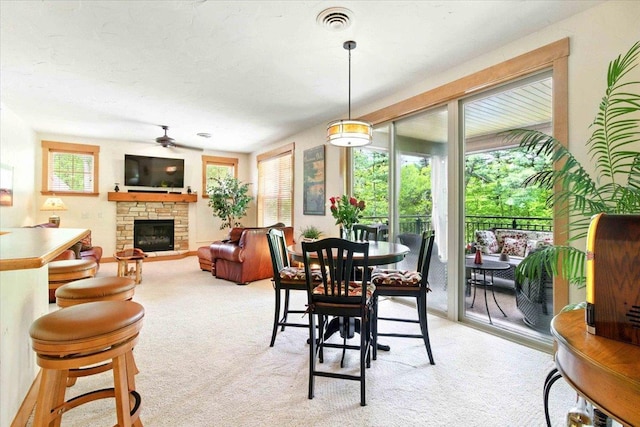 441 Clara Ave Unit 115, Wisconsin Dells, WI 53965 - dining area featuring a ceiling fan, a fireplace, and light colored carpet