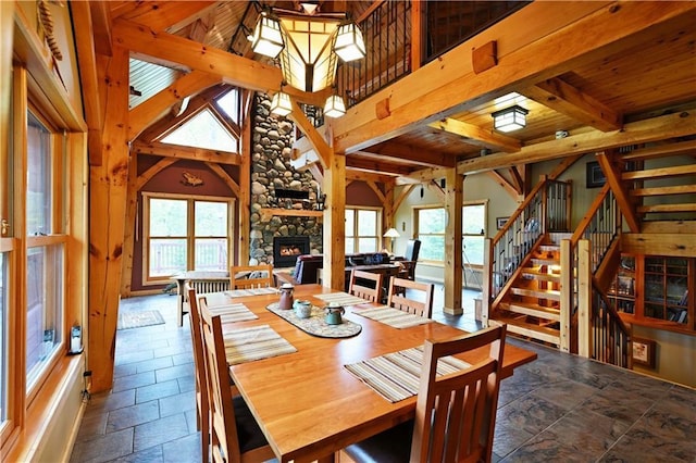 10435 W Murphy Blvd, Hayward, WI 54843 - dining area featuring healthy amount of natural light, a fireplace, stone tile flooring, stairs, and wood ceiling with exposed beams