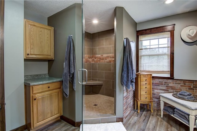 N1816 950th St, Eau Claire, WI 54701 - full bath featuring wood finished floors, a shower stall, recessed lighting, baseboards, and a textured ceiling