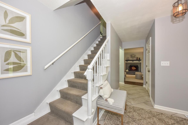 1429 W River Oaks Ln, Mequon, WI 53092 - staircase featuring baseboards, tile patterned flooring, and a fireplace