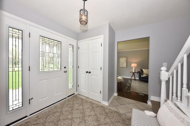 1429 W River Oaks Ln, Mequon, WI 53092 - entrance foyer with stairs, light tile patterned flooring, and baseboards