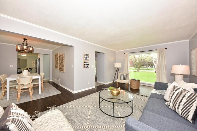 1429 W River Oaks Ln, Mequon, WI 53092 - living room featuring wood finished floors, a chandelier, baseboards, and ornamental molding