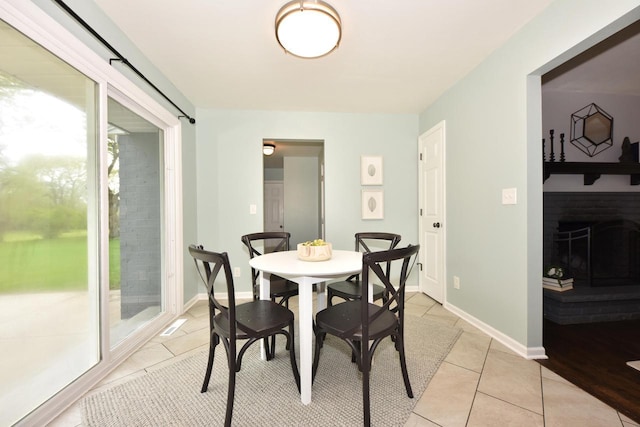 1429 W River Oaks Ln, Mequon, WI 53092 - dining space featuring light tile patterned flooring, a fireplace, and baseboards