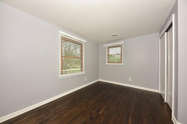 1429 W River Oaks Ln, Mequon, WI 53092 - unfurnished bedroom featuring dark wood-type flooring, baseboards, and a closet