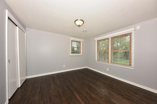 1429 W River Oaks Ln, Mequon, WI 53092 - unfurnished bedroom with baseboards, dark wood-style floors, and a closet