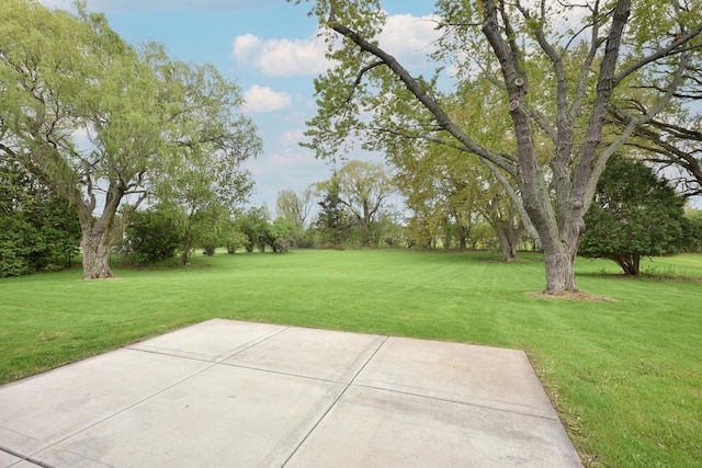 1429 W River Oaks Ln, Mequon, WI 53092 - view of green lawn featuring a patio area and view of wooded area