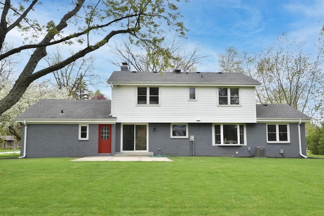 1429 W River Oaks Ln, Mequon, WI 53092 - rear view of property featuring central AC, a chimney, a patio area, brick siding, and a yard