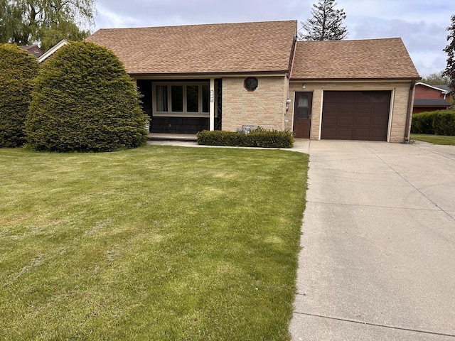 2109 Salisbury Rd, West Bend, WI 53090 - view of front of home with driveway, an attached garage, a front yard, roof with shingles, and brick siding